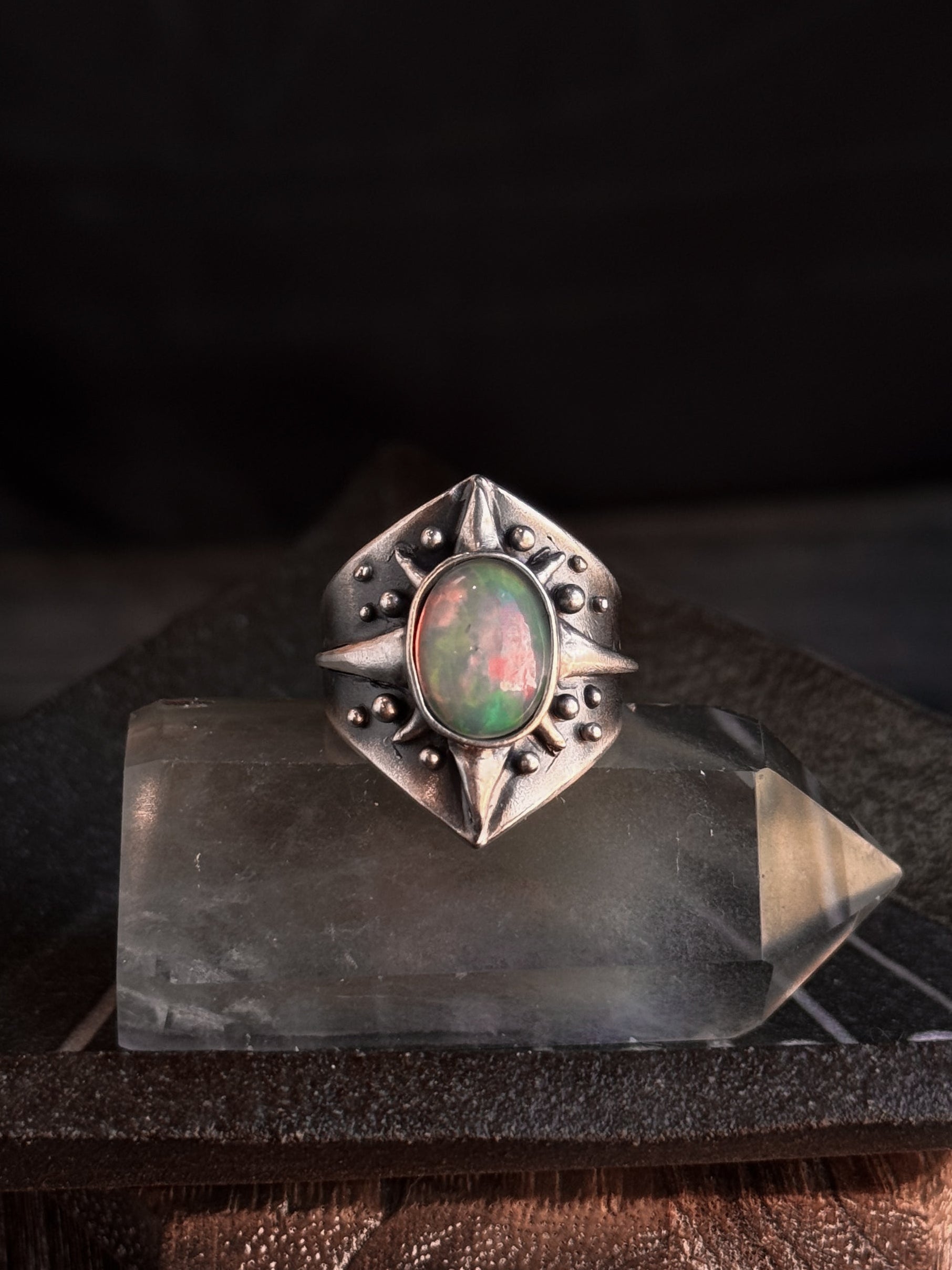 Silver ring with an opal stone on a dark background